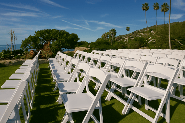 White padded chair rentals set up for outdoor wedding in Central Florida.